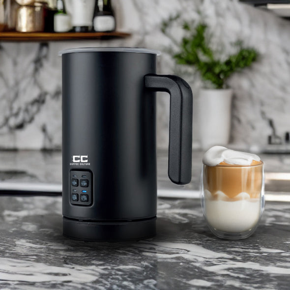 coffee culture black electric milk frother next to a coffee cup with froth milk in a kitchen